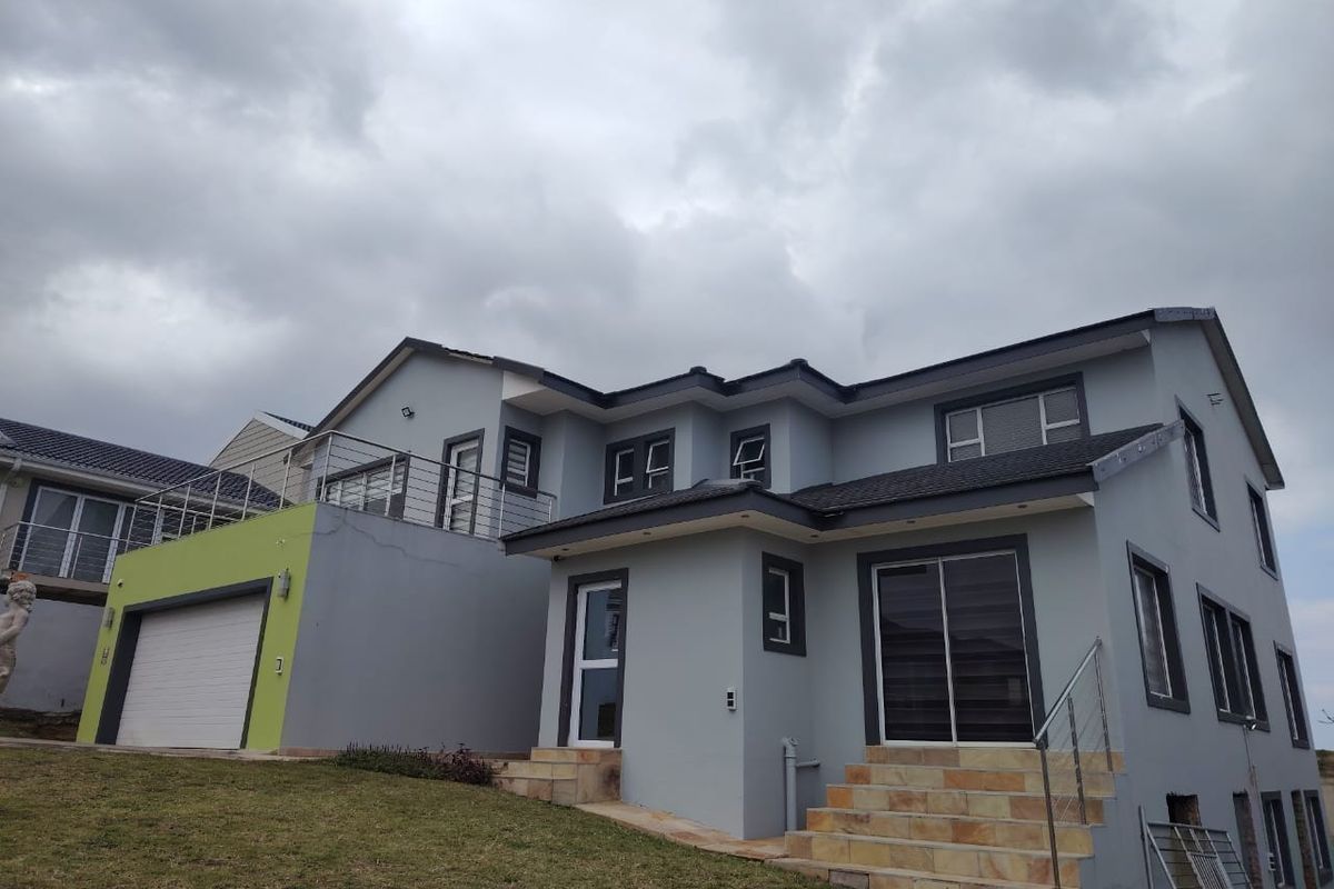Rear view of a modern two-story house featuring a tiled staircase, stainless steel balustrades, sliding glass doors, and an integrated garage.