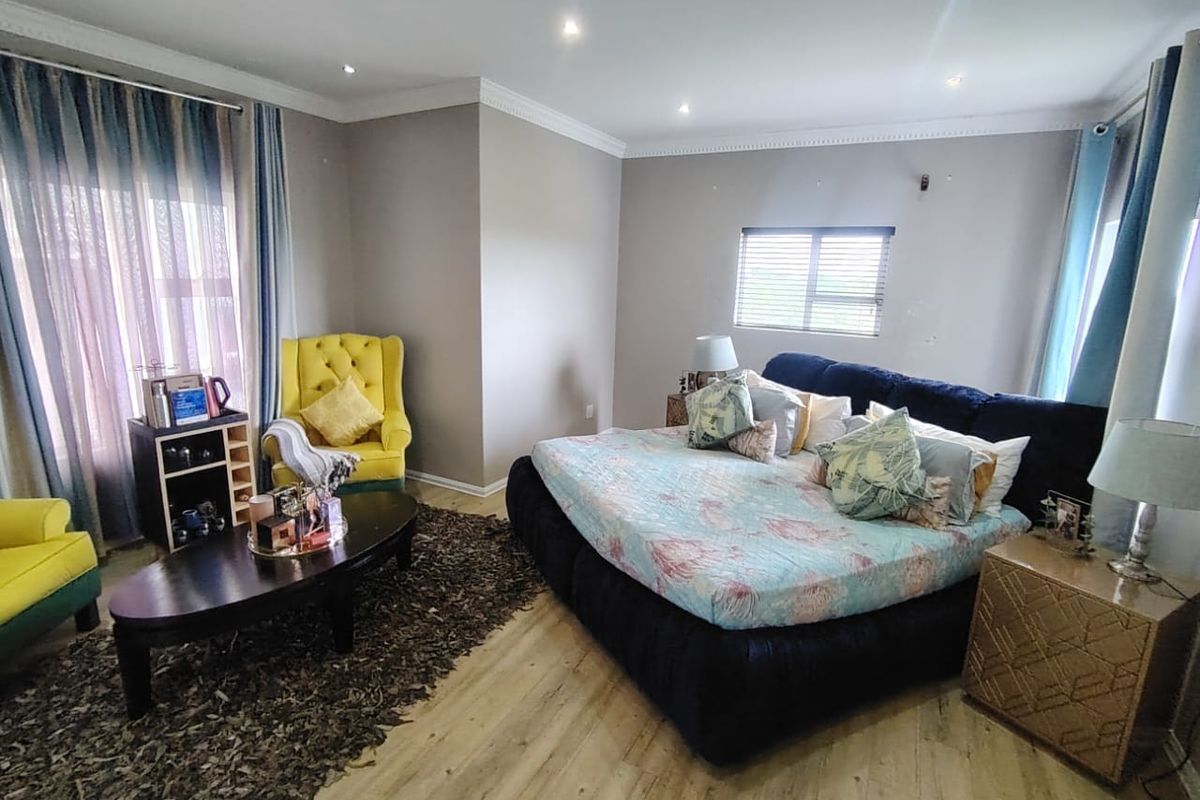Spacious bedroom featuring laminate flooring, recessed downlighting, and coved ceiling details, providing a comfortable and well-maintained living space.