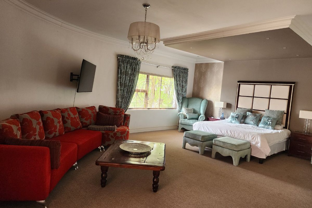 Spacious bedroom featuring carpeted flooring, recessed ceiling lighting, decorative cove molding, and a large window with security bars.