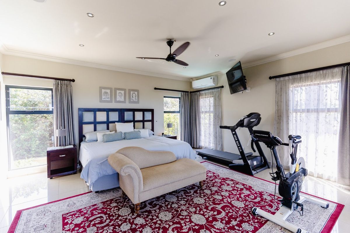 Spacious bedroom featuring tiled flooring, recessed lighting, a ceiling fan, and a wall-mounted air conditioning unit.