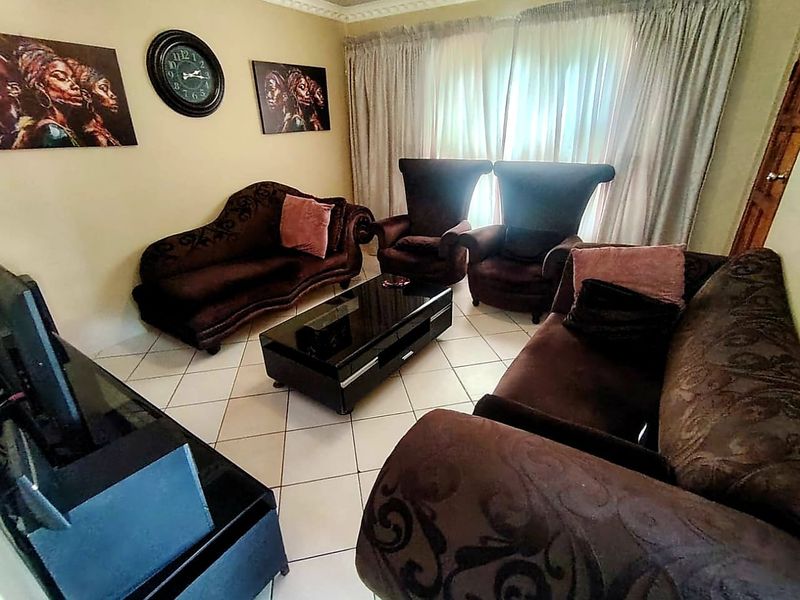 A comfortable living room featuring tiled flooring and decorative crown molding, providing a functional space for relaxation.