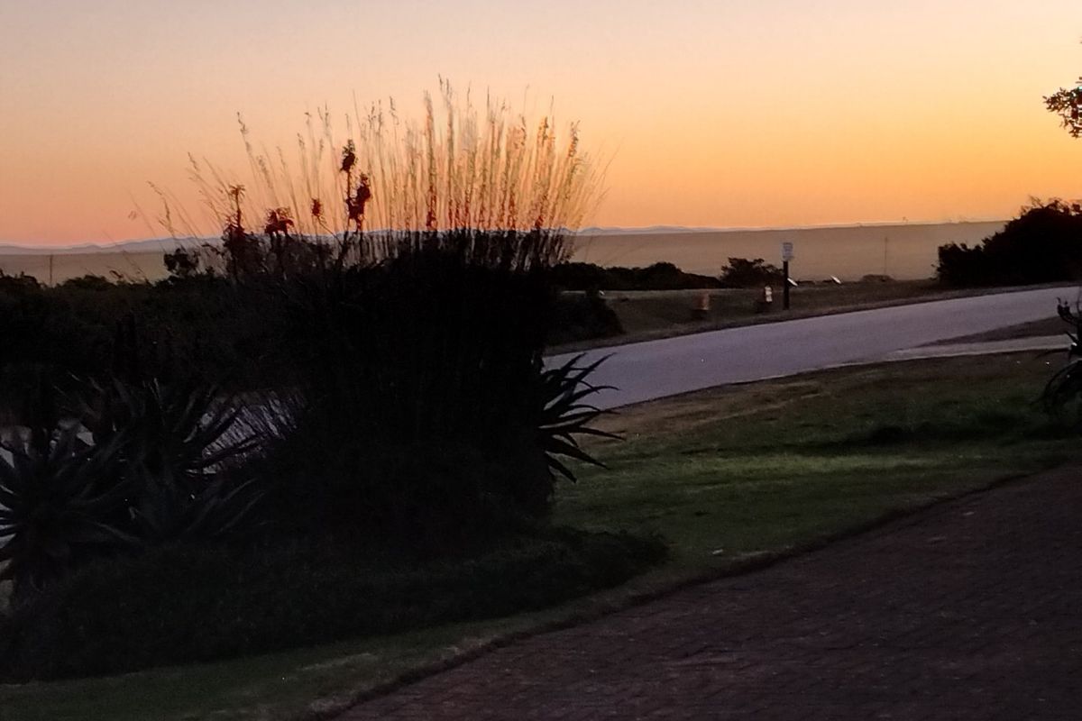 A scenic view of the surrounding landscape at sunset, showcasing the natural beauty and horizon of the residential area.
