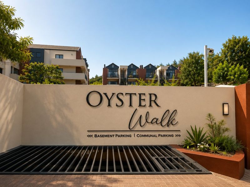 Entrance signage for Oyster Walk apartment complex, featuring a modern retaining wall, security camera, and clear directional signage for parking facilities.