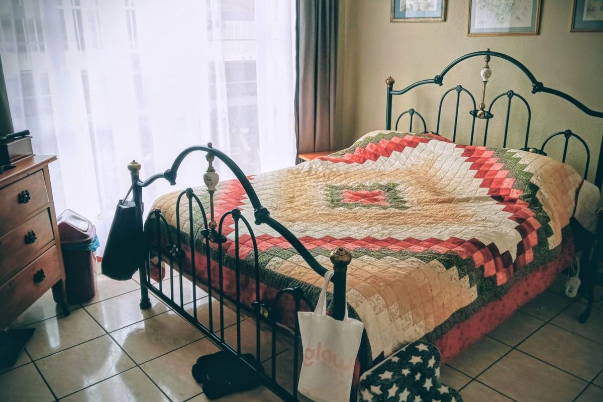 A bedroom featuring tiled flooring and a large sliding glass door providing natural light.