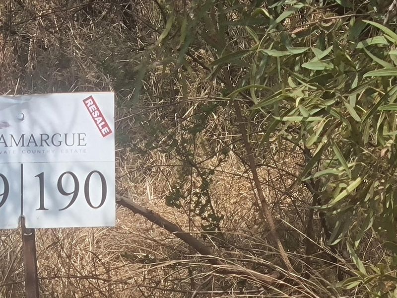 A close-up view of a property signage board located on a vacant residential plot within a country estate.