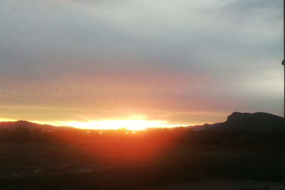 A scenic sunset view overlooking the landscape and distant mountains from the property.