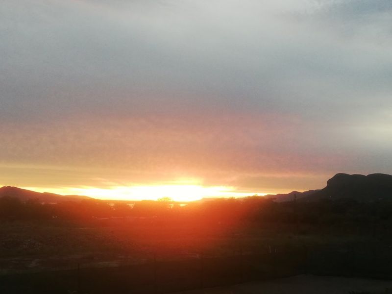 A scenic sunset view overlooking the landscape and distant mountains from the property.