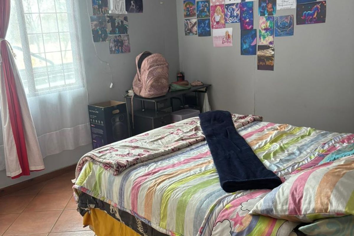 A functional bedroom featuring tiled flooring and a window, providing a neutral base for personalization.