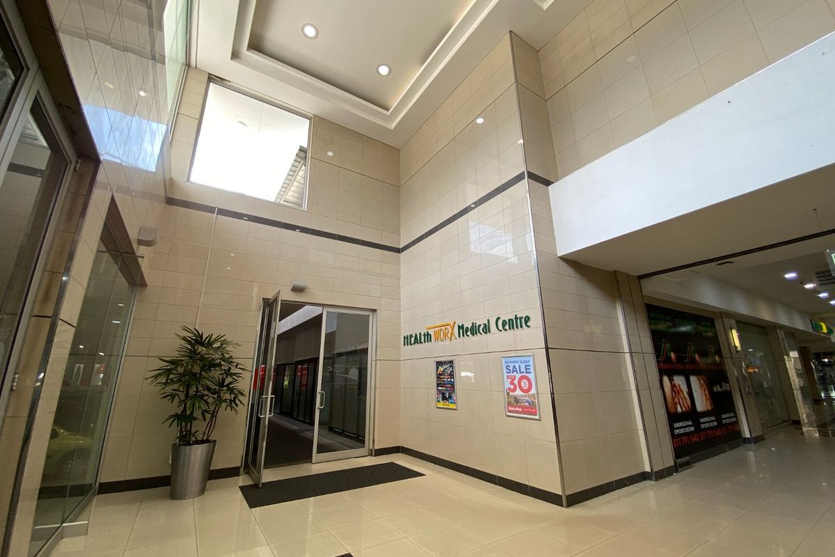 Spacious commercial entrance lobby featuring high ceilings, ceramic wall tiles, and polished floor tiles, providing a professional and bright reception area.