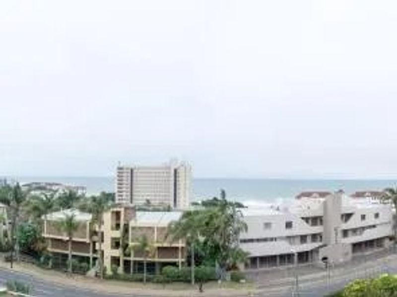 An elevated view overlooking the surrounding coastal neighborhood, nearby apartment complexes, and the ocean horizon.