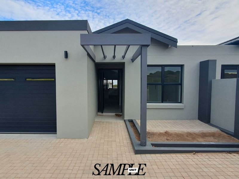 Modern front facade featuring a paved driveway, integrated garage, and a contemporary pergola entrance with clean architectural lines.