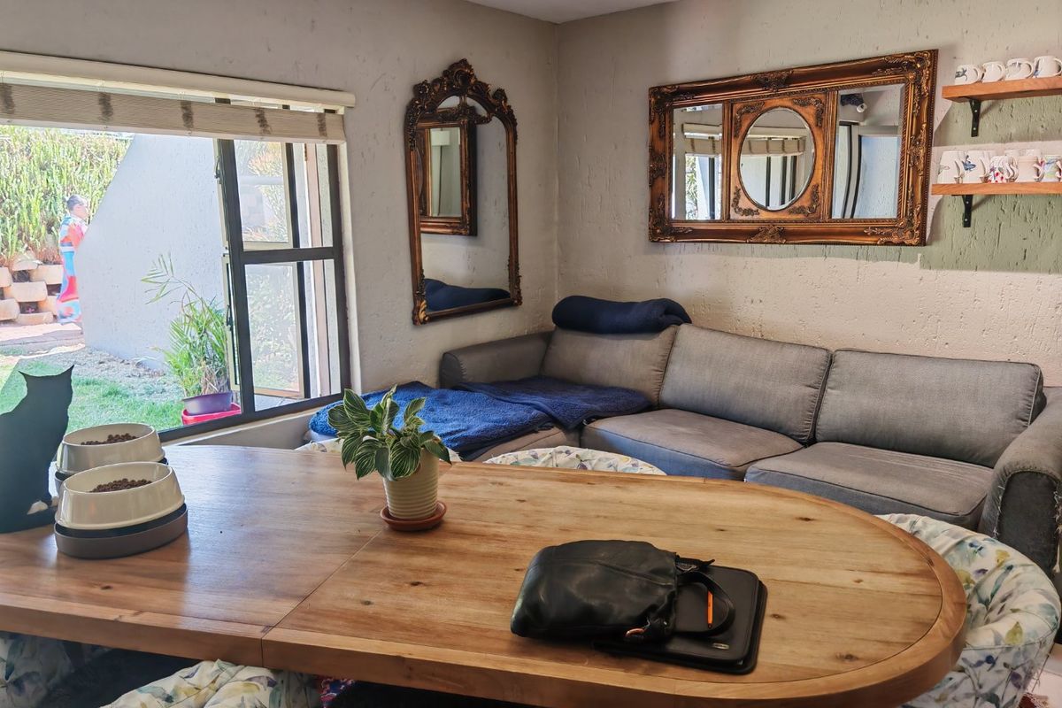 A cozy living area featuring textured walls, recessed lighting, and a large sliding window providing natural light and access to the outdoor space.