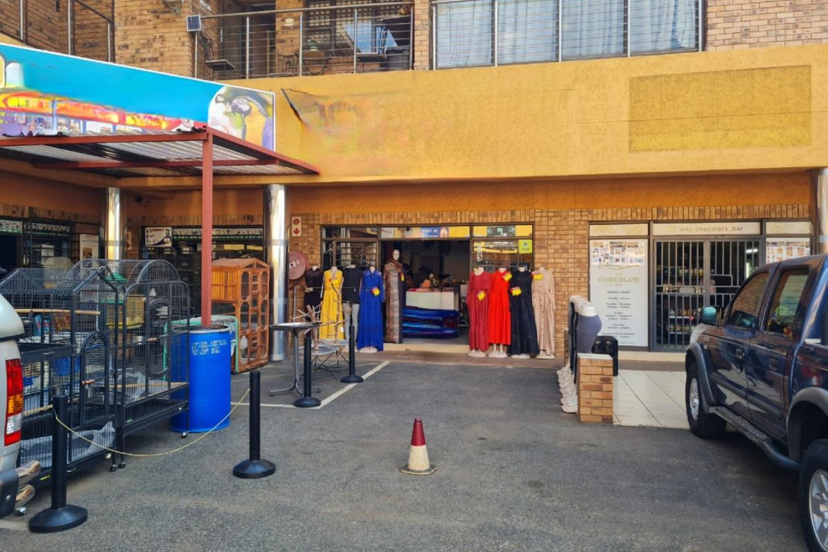 Commercial storefront featuring a brick facade, glass entrance, and covered walkway area, suitable for retail or service-based business operations.