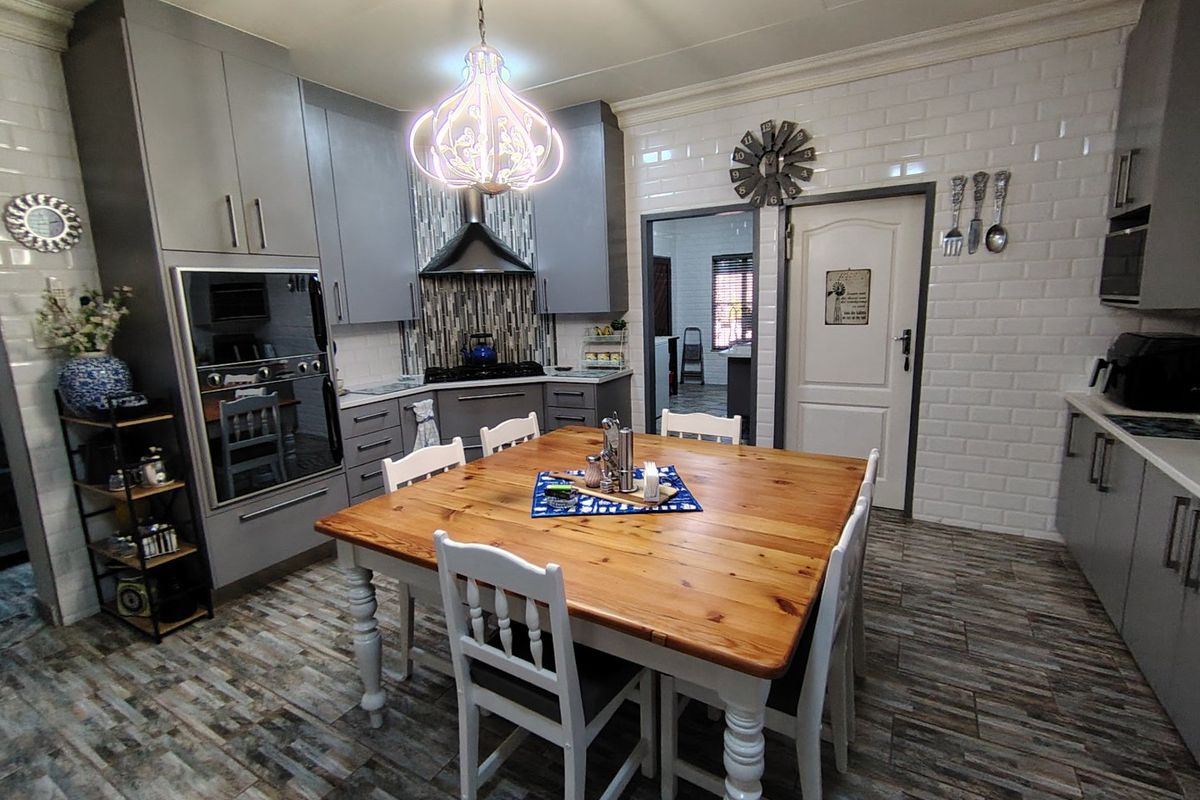 Modern kitchen featuring grey cabinetry, subway tile backsplash, built-in oven and microwave, and durable tiled flooring.