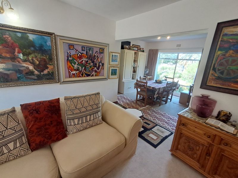 Open plan living and dining area featuring neutral carpeting, built-in cabinetry, and large sliding glass doors providing natural light and garden access.