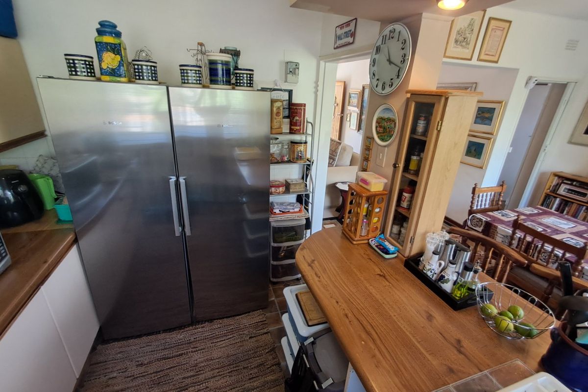 A functional kitchen area featuring wooden countertops, built-in cabinetry, and a tiled backsplash, providing a practical workspace with integrated storage solutions.