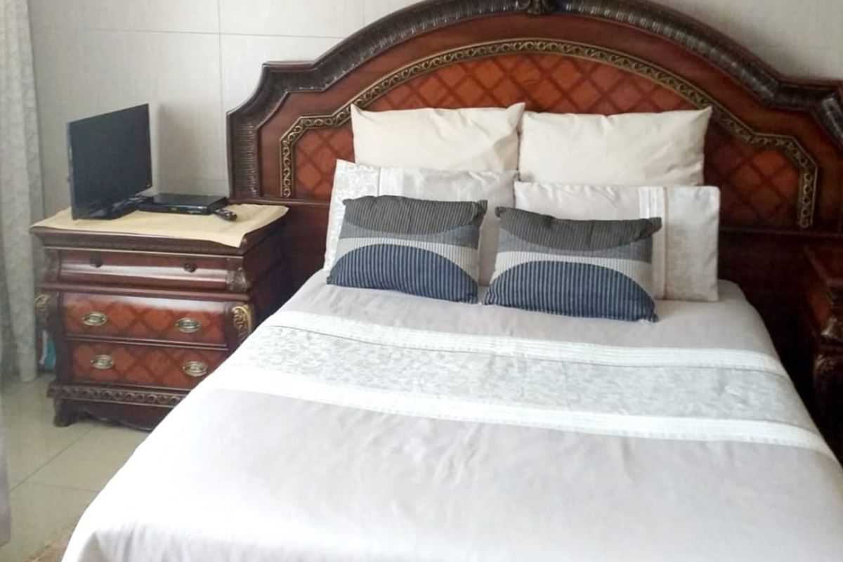 A bedroom featuring tiled flooring and neutral wall finishes, providing a functional space for rest.