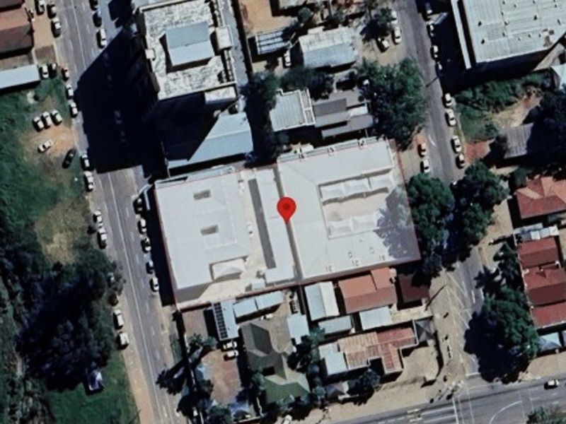 Aerial view of the commercial property showing the building footprint, roof layout, and surrounding street access.