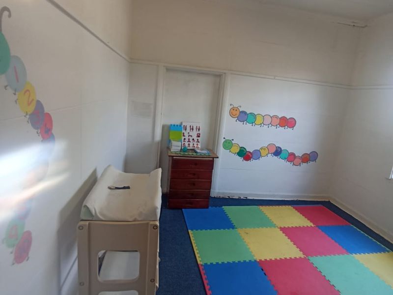 A multi-purpose room currently used as a play area, featuring basic finishes and fluorescent lighting.