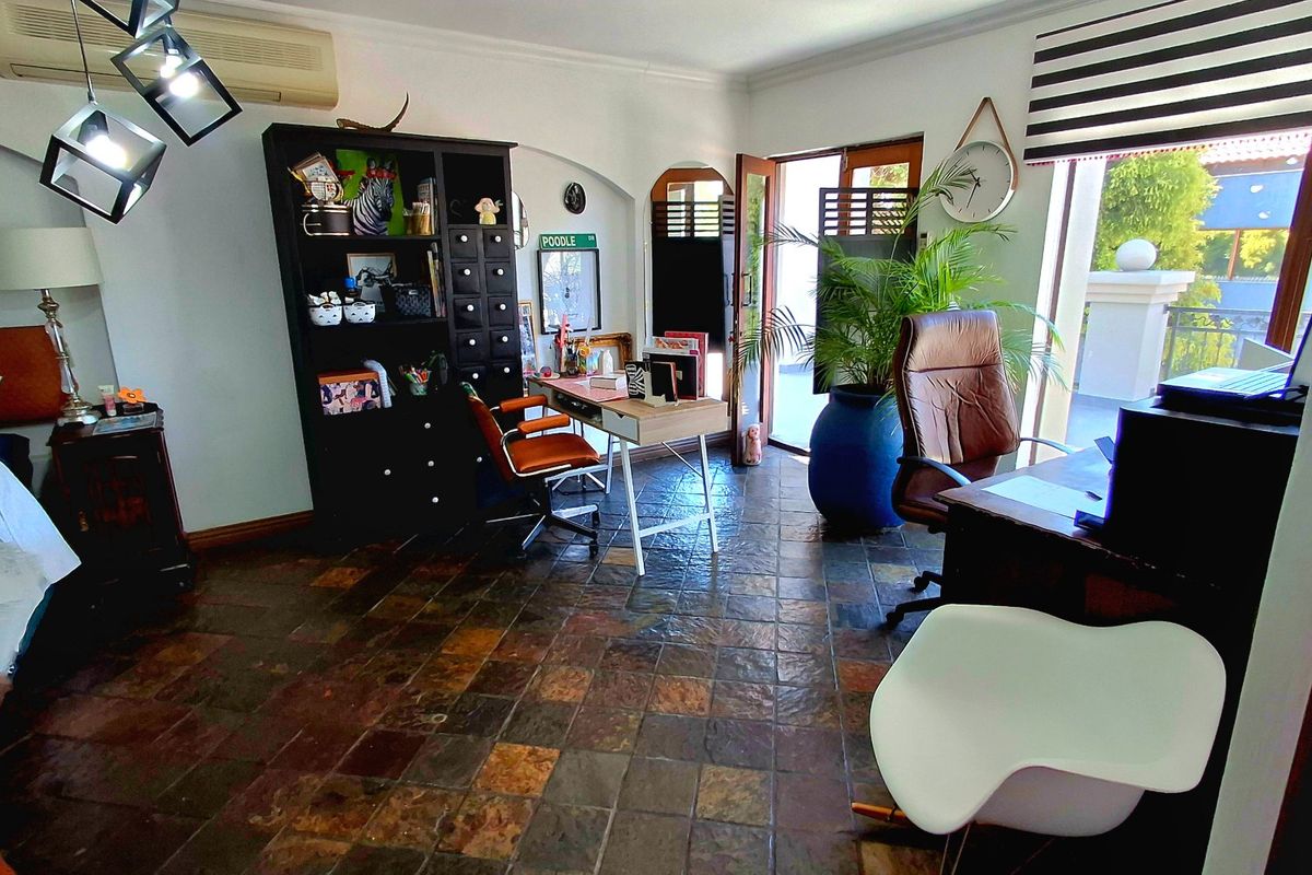 Spacious bedroom featuring durable slate tile flooring, an integrated split-system air conditioner, and direct access to an outdoor area through a sliding glass door.