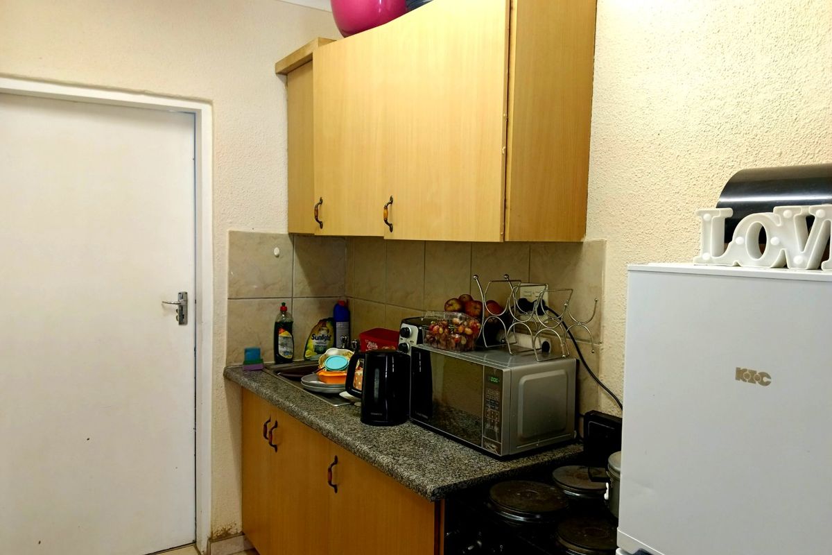 Compact kitchen featuring laminate cabinetry, granite countertops, a tiled backsplash, and an integrated electric stove.