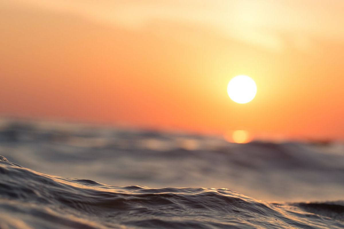 A scenic view of the ocean at sunset, highlighting the natural landscape and coastal setting of the property.