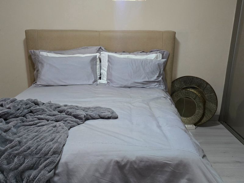 A bedroom featuring laminate flooring and a built-in wardrobe with sliding doors.