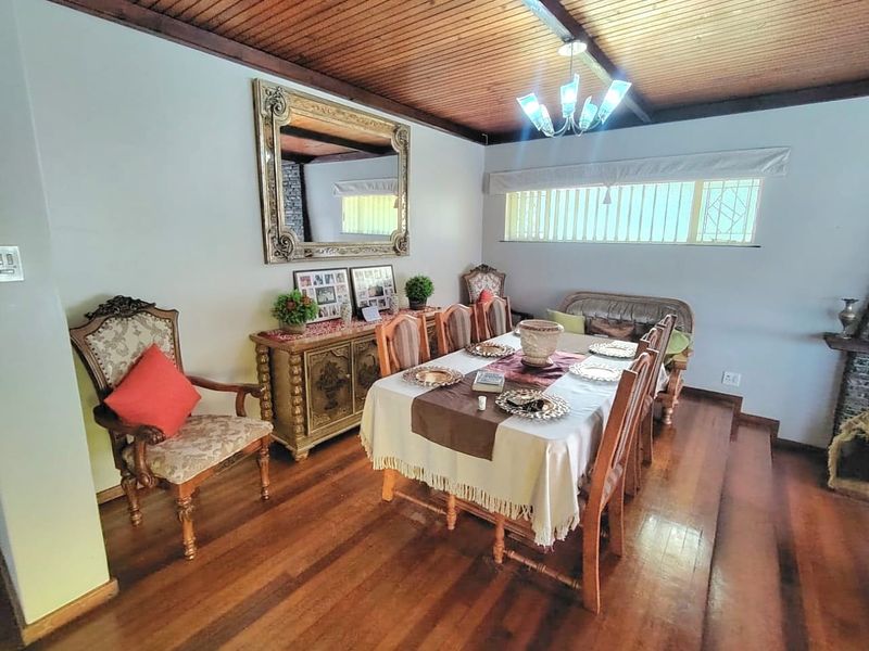 A dining room featuring warm hardwood flooring and a classic timber-paneled ceiling, creating a traditional and inviting atmosphere for family meals.