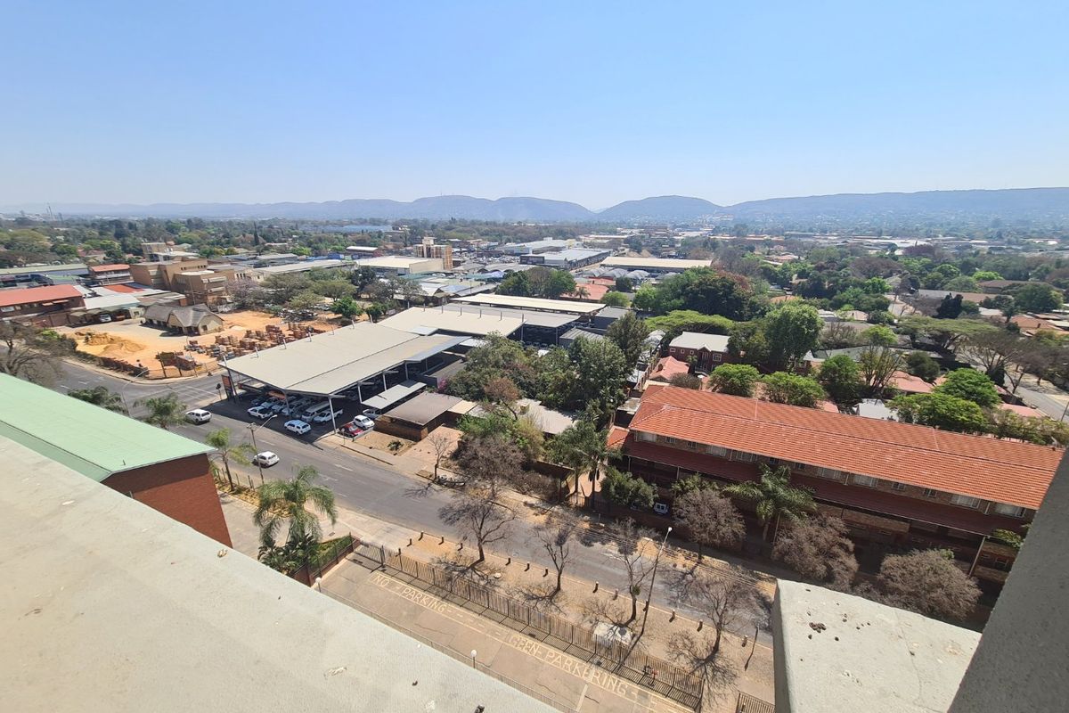 Elevated aerial view overlooking the surrounding commercial and residential neighborhood with mountain vistas in the distance.