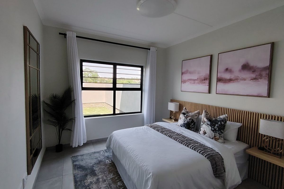 A well-maintained bedroom featuring modern tiled flooring, a stylish timber slat headboard with integrated bedside shelving, and large windows with security bars.