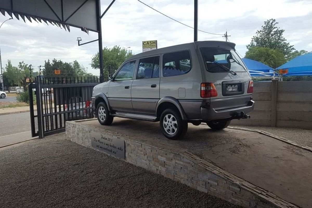 Commercial display area featuring a raised stone-clad platform under a metal roof structure, suitable for vehicle showcasing.