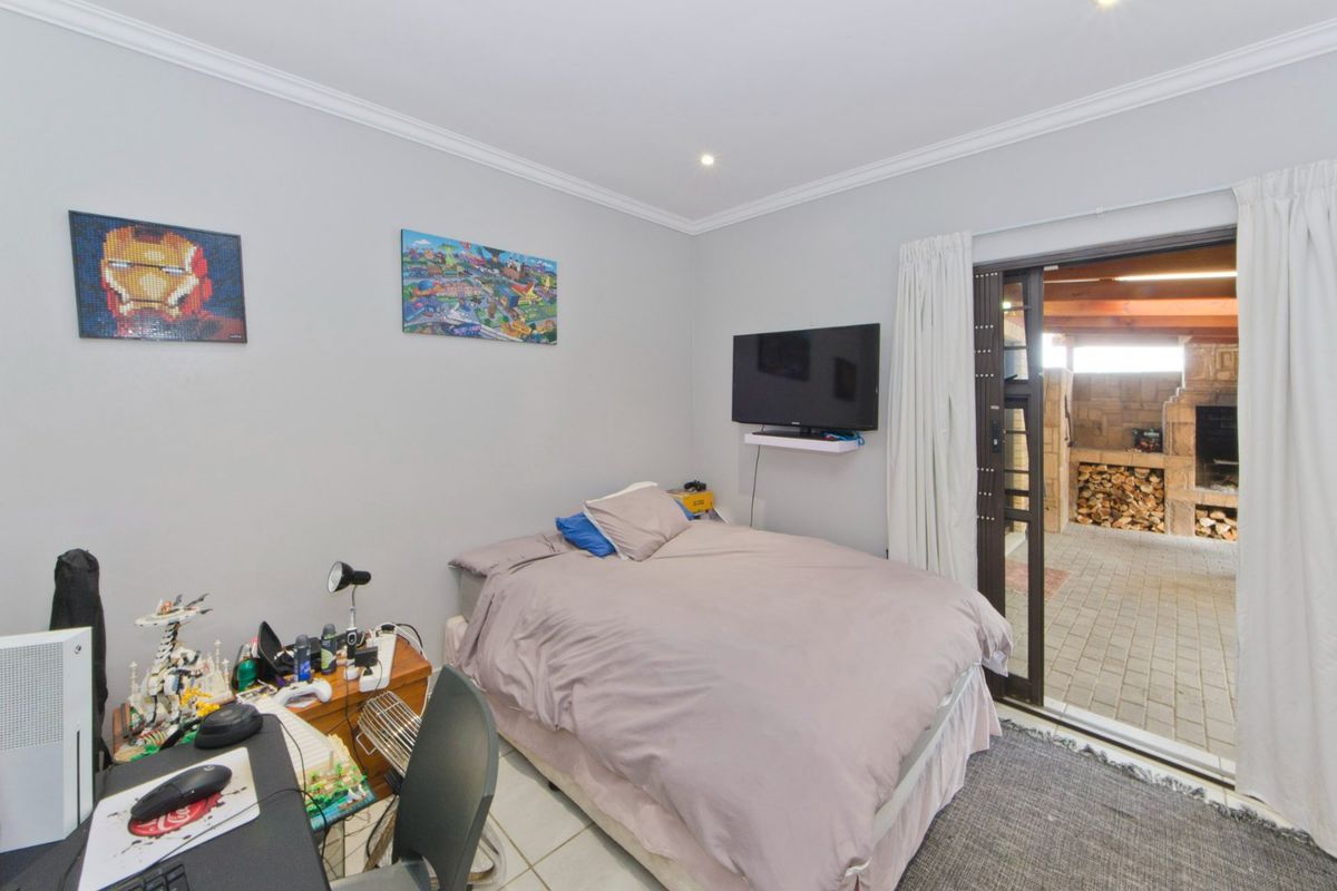 A bedroom featuring tiled flooring, recessed downlighting, and a sliding glass door providing direct access to an outdoor patio area.
