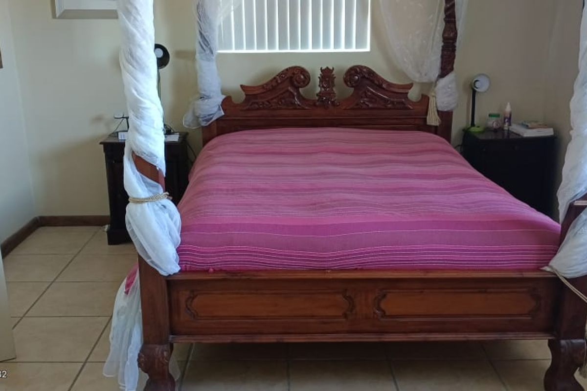 A bedroom featuring tiled flooring and a window with fitted blinds.
