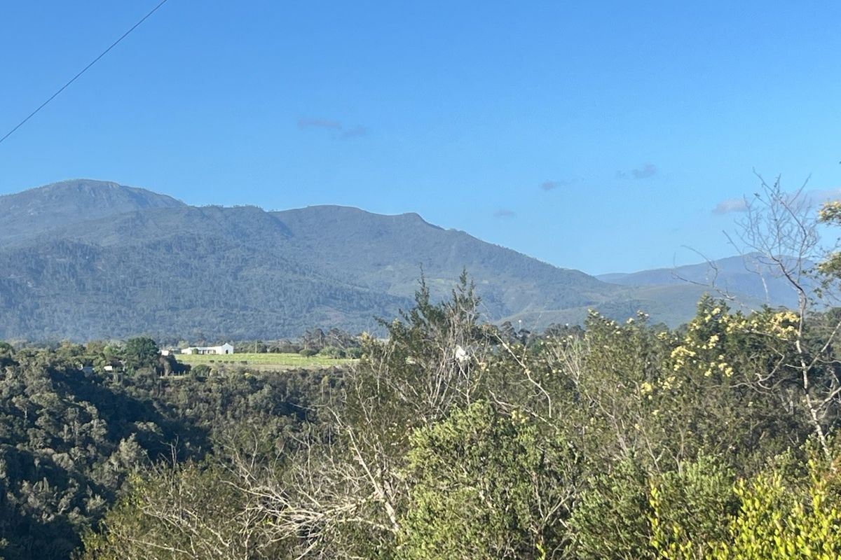 A scenic landscape view showcasing rolling hills and mountain ranges, highlighting the natural beauty and surroundings of the vacant residential land.