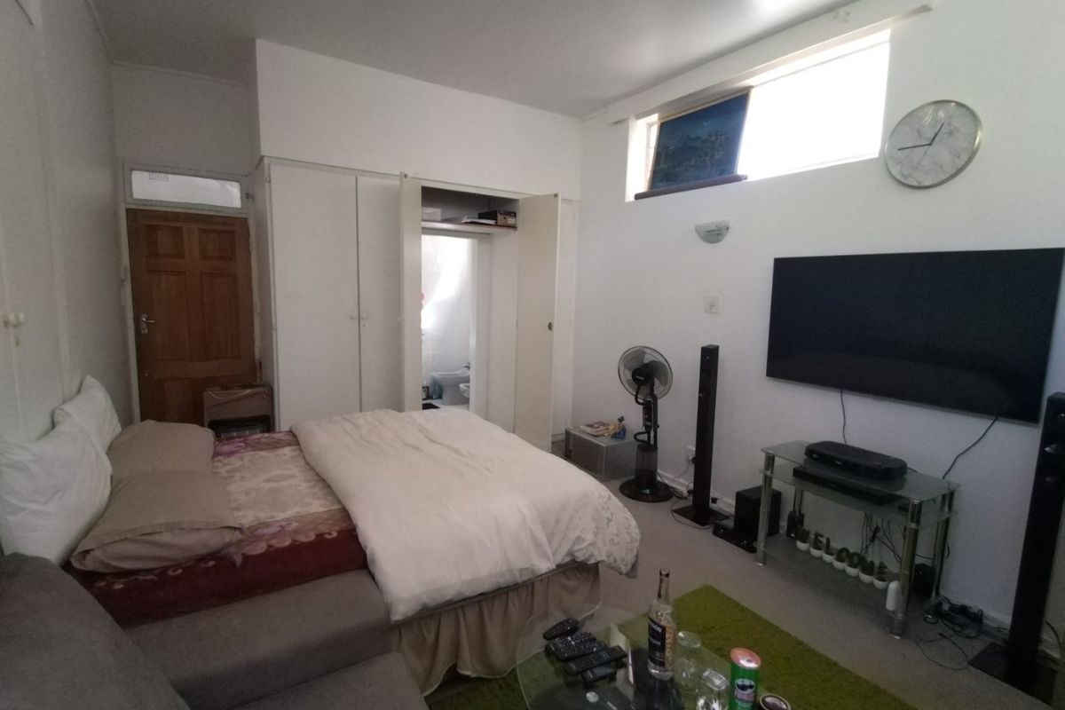 A bedroom featuring built-in wardrobe storage, a high-level window for natural light, and direct access to an adjoining bathroom.
