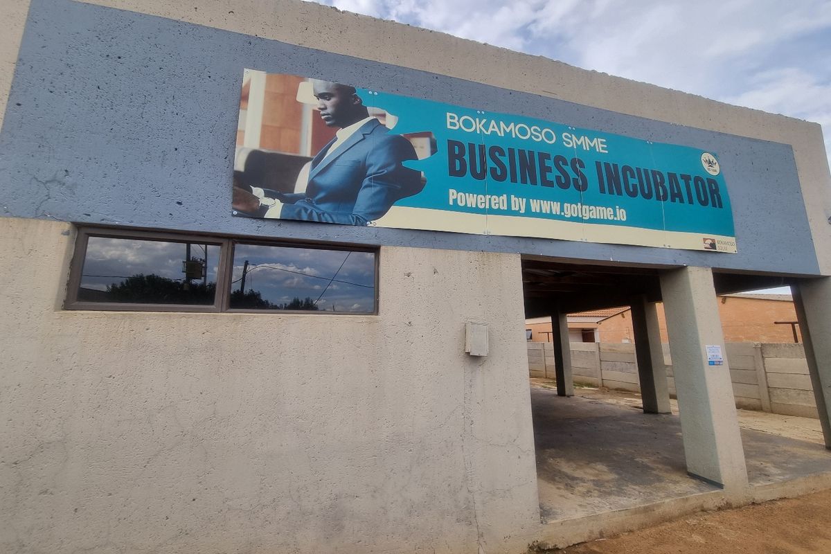 Exterior view of a commercial business incubator building featuring a prominent signage board and a covered entrance area.