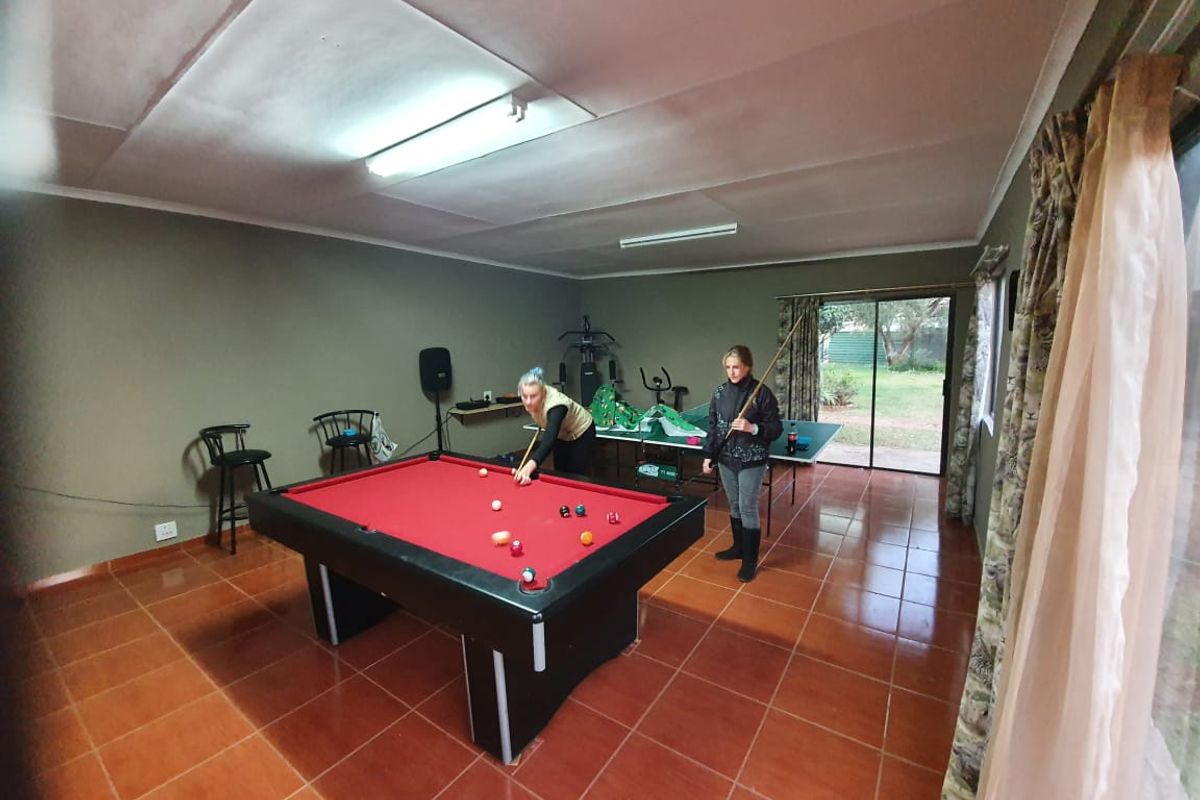 A multi-purpose living area featuring tiled flooring and sliding glass doors providing access to the garden.