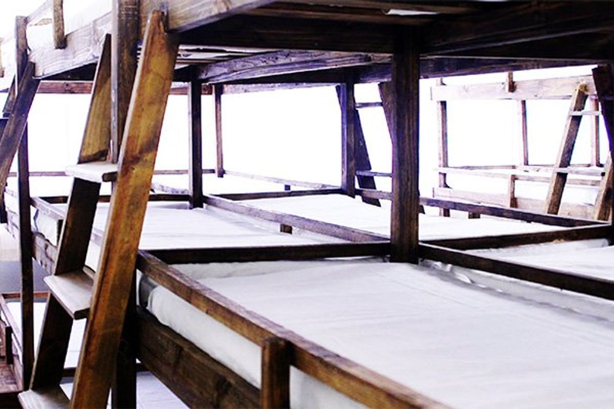 A dormitory-style bedroom featuring multiple built-in wooden bunk bed frames.
