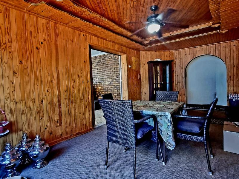 Dining area featuring extensive timber wall paneling and a matching timber ceiling with an integrated fan.
