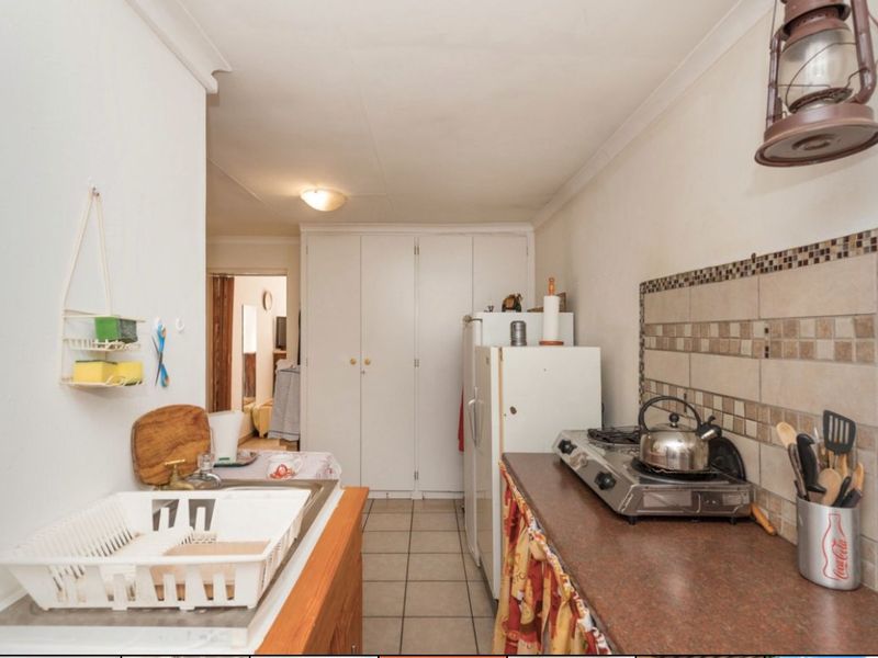 1 Bed Simplex – Secure and Pet-Friendly Starter Home  This neat 1-bedroom simplex offers a great opportunity for first-time buyers or investors. With 39 m2 of living space, the unit includes an open-plan lounge and a functional kitchen with wooden counter tops. The bathroom is compact and convenient, and one covered carport is included.  The unit is pet-friendly and features good security with Spanish bars on the windows and a security gate. The complex offers added peace of mind with armed response, a panic button system, remote-controlled access, and an intercom.  Affordable, secure, and well-located—don’t miss out! Contact us today to arrange a viewing. - Photo 6