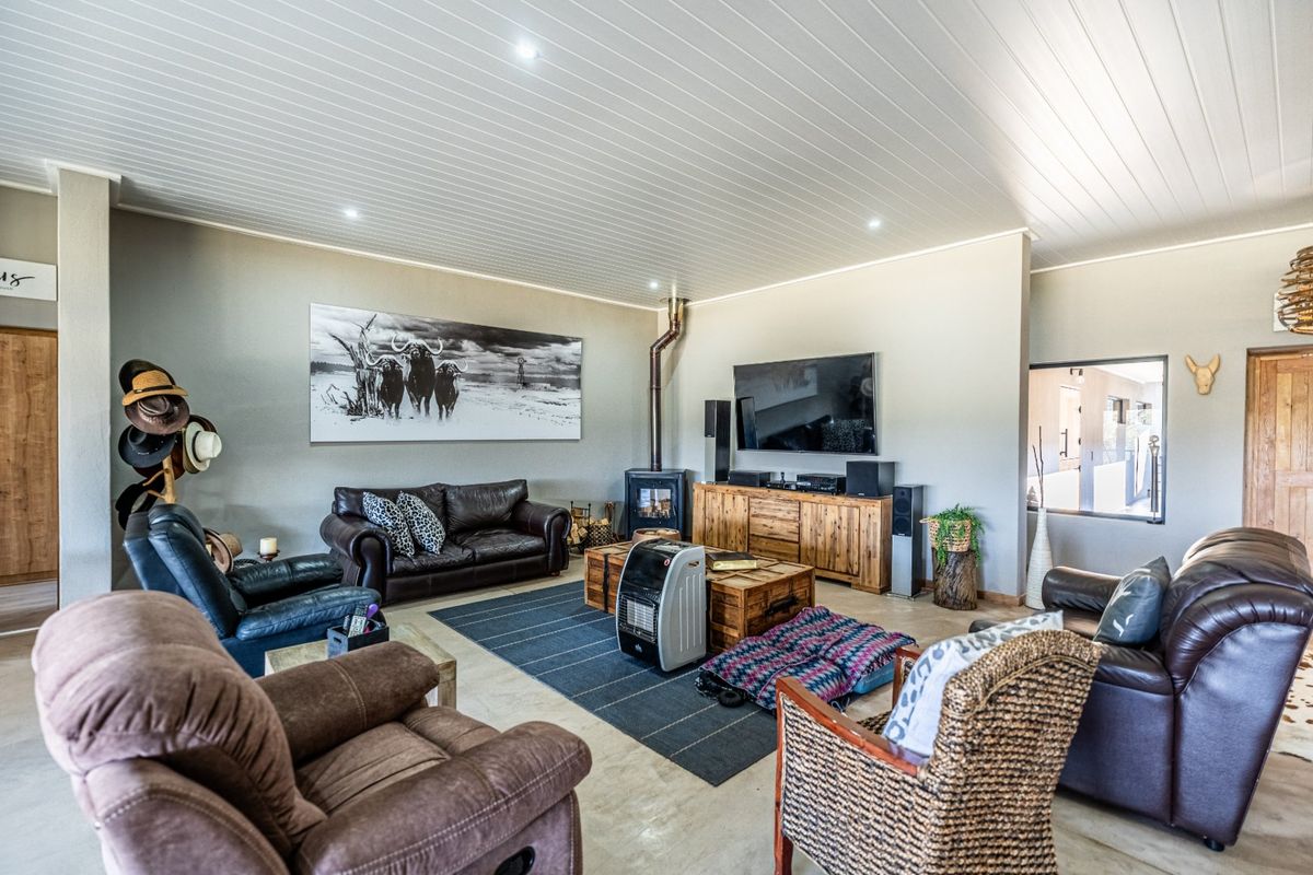 Spacious living room featuring a wood-burning fireplace, polished concrete floors, and a modern tongue and groove ceiling with recessed lighting.
