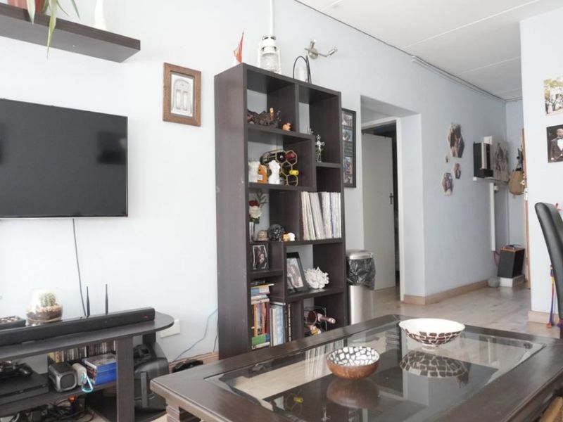 A living room area featuring laminate flooring and neutral wall finishes, providing a functional space for relaxation.