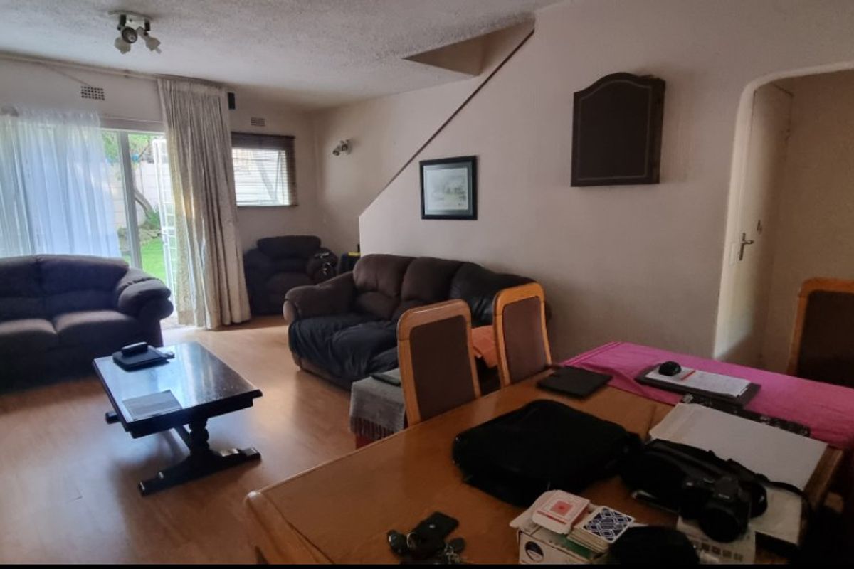Open plan living and dining area featuring laminate flooring and sliding glass doors leading to the exterior.