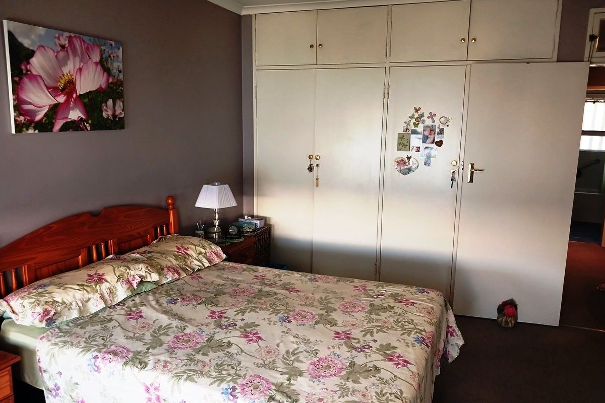 A bedroom featuring extensive floor-to-ceiling built-in cupboards providing ample storage space.