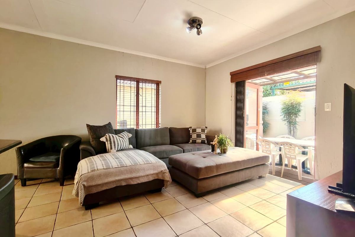 A living room featuring tiled flooring and a sliding door providing direct access to an outdoor patio area.