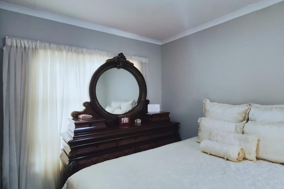 A well-maintained bedroom featuring neutral wall tones and classic cove cornicing, providing a clean and comfortable living space.