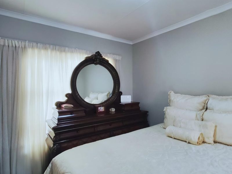 A well-maintained bedroom featuring neutral wall tones and classic cove cornicing, providing a clean and comfortable living space.
