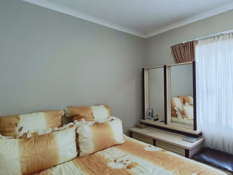 A bedroom featuring neutral wall tones, coving, and a window with installed curtain rods.