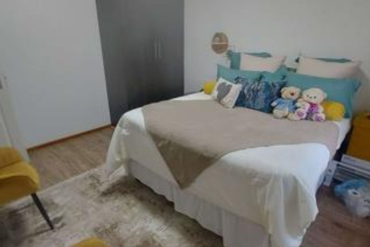 A bedroom featuring laminate flooring and a built-in wardrobe.