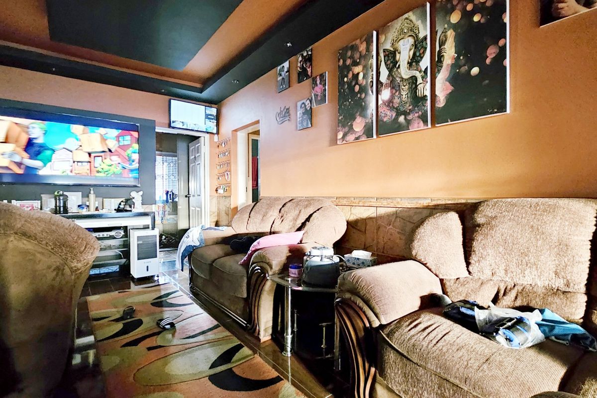 A living room featuring a recessed ceiling design and stone-effect wall cladding, providing a distinct architectural character to the space.